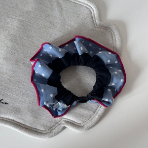 Close-up of blue polka dot denim scrunchie with red piping and elastic inner core
