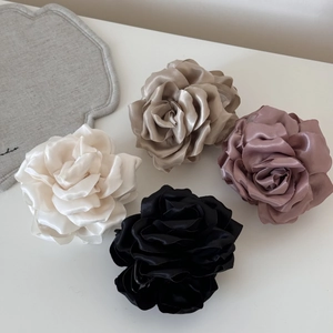 Détail de quatre pinces à cheveux rose en satin blanc, champagne, rose et noir