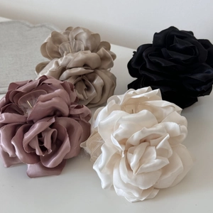 Détail de quatre pinces à cheveux rose en satin coloris rose champagne et noir