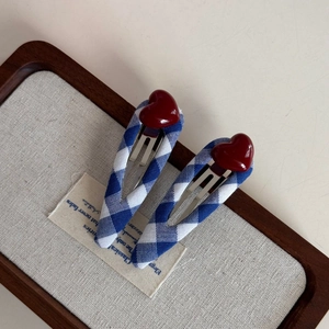 Set of blue and white gingham BB hair clips with red 3D hearts on a wooden tray