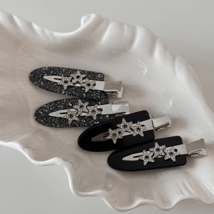 Macro shot of 4-piece star-studded hair clips set on a decorative white shell tray