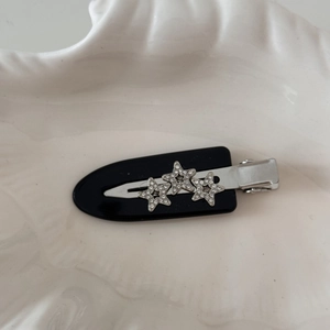 Detailed view of three shimmering rhinestone stars on an elegant acetate duckbill hair clip
