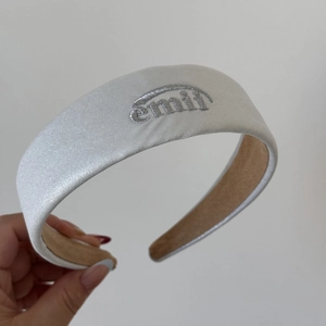 Détail d'un serre-tête argenté scintillant avec broderie emmi et doublure en daim