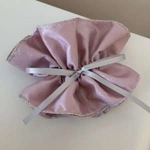 Détail de la pochette en tissu nacré rose clair avec cordon de serrage argenté