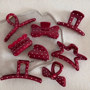 Set of 8 red polka dot hair claws in various shapes like hearts and bows on a neutral background