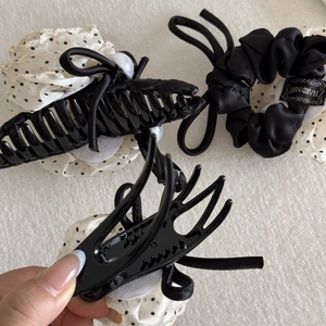 Detail view of polka dot chiffon bow hair claw and black satin scrunchie hair accessory set