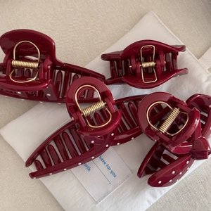 Set of four large burgundy claw clips with white polka dots and gold metal springs