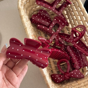 Detail of burgundy polka dot hair claws with gold springs in a woven basket