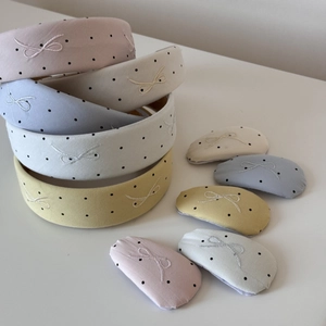 Detailed view of colorful polka dot embroidered bow headbands and matching hair clips