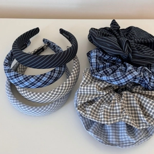 Flat lay detail showing classic plaid and checkered cotton scrunchies and headbands