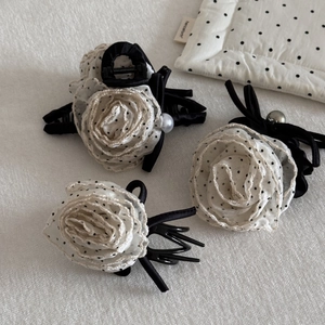 Detailed view of three polka dot cream rose hair claws with organza and pearls