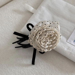 Detail of elegant hair claw clip with polka dot mesh flower and delicate lace edges
