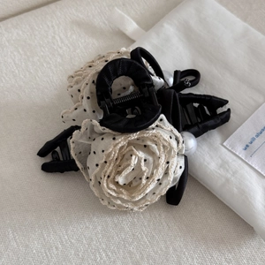 Detailed shot of black hair claw clip with cream polka dot rose and lace trim