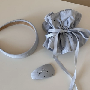 Close-up of light blue polka dot headband with bow embroidery and matching accessories