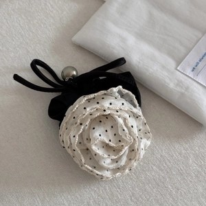 Detail of rose hair clip with cream polka dot chiffon petals and silver bead accent