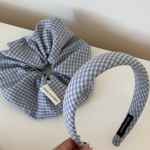 Detail view of blue and white checkered scrunchie and padded headband set with handmade labels