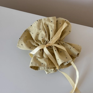 Detail of beige polka dot drawstring hair accessory with an elegant silk bow knot