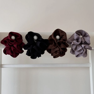 Close-up of four oversized scrunchies in wine red, black, coffee, and light purple tones