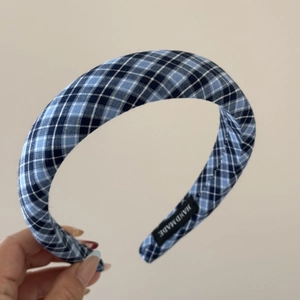 Detail of blue lace plaid scrunchie featuring a handmade label and cotton fabric texture