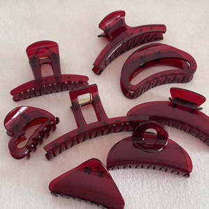 Set of eight minimalist transparent burgundy hair claw clips in various geometric shapes