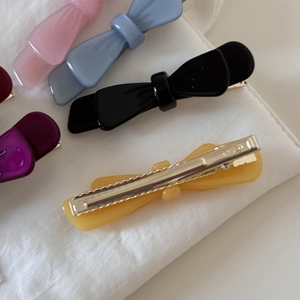 Detailed close-up of double-layer acetate bow hair clips with metal alligator clips