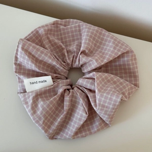 Close-up of pink and white gingham scrunchie featuring a handmade woven label detail