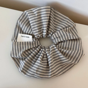 Detail of a handmade black and white striped scrunchie with a woven tag