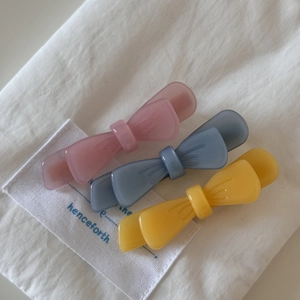 Minimalist double-layer acetate bow hair clips in pink, blue, and yellow matte finish