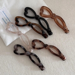 Detailed view of six resin banana hair clips with heart cut-outs in various colors