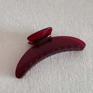 Macro shot of burgundy translucent acrylic hair claw clip with double row interlocking teeth