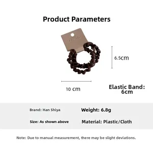 Detailansicht brauner Spiral-Haargummis mit gerippter Stofftextur und elastischem Design