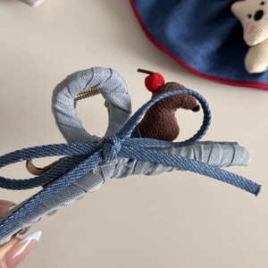 Détail de la pince à cheveux en denim bleu avec nœud et petit animal en peluche mignon