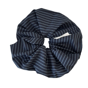 Blue and grey striped scrunchie in cotton blend fabric with pleated design on white background