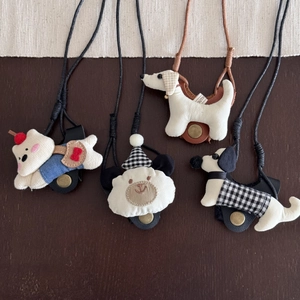 Detail view of cute fabric animal pendants with adjustable neck lanyards and metal snaps