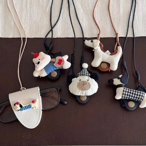 Puppy and bear themed hanging eyewear holders with lanyards on wooden table
