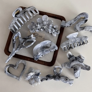 Detailed collection of grey marble acetate hair claws in flower and star shapes