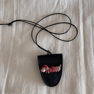 Detail of black leather dog glasses holder pendant with cute dachshund and lanyard