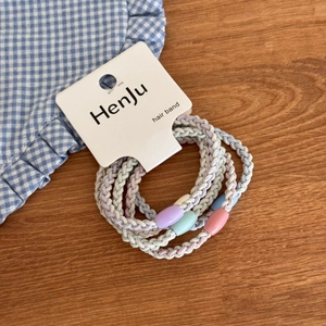 Set of 4 pastel braided hair ties with decorative beads displayed on a wooden surface