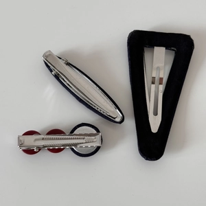 Detailed back view of navy plaid hair clips with various metal spring and snap fasteners