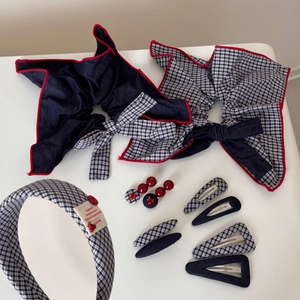 Close-up of navy gingham fabric hair clips and vintage style bow accessories set