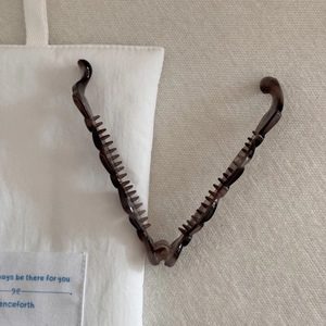 Détail de la pince à cheveux banane en résine ambrée ouverte avec dents internes