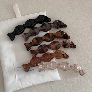 Détail de 6 pinces à cheveux en forme de bonbon en résine brillante de diverses couleurs