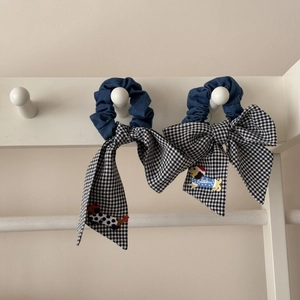 Détail de chouchous en denim avec longs nœuds vichy et broderie de teckel mignonne