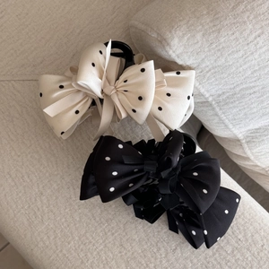 Vue détaillée macro de pinces à cheveux à nœuds à pois en tissu de satin chic