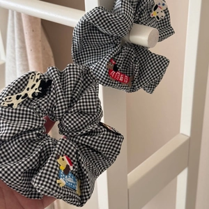 Gros plan détaillé sur la broderie de chien mignon du chouchou vichy noir et blanc