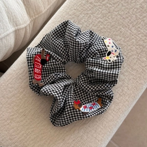 Détail du chouchou vichy noir et blanc avec écussons brodés de chiens mignons