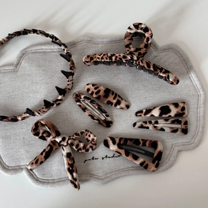 Detail of elegant leopard print hair accessory set featuring claw clips and headbands