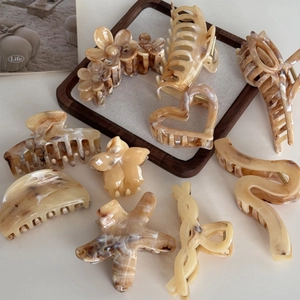 Barrettes à cheveux ambre en forme d'étoile de mer et fleur sur plateau en bois