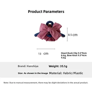Detail view of a red plaid fabric bow hair clip showing exact size 13cm by 8.5cm