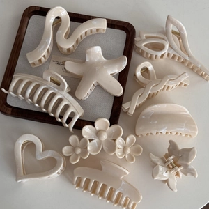 Detailed set of cream marble texture hair claws in star, heart and flower shapes
